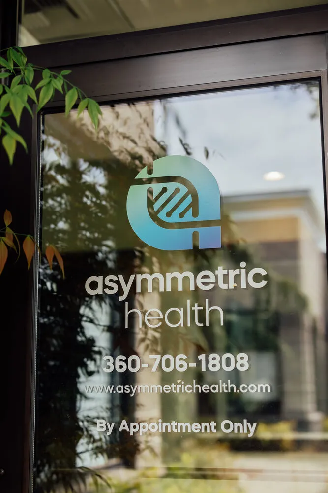Asymmetric Health logo etched on the glass door of Suite C, with phone number 360-706-1808
