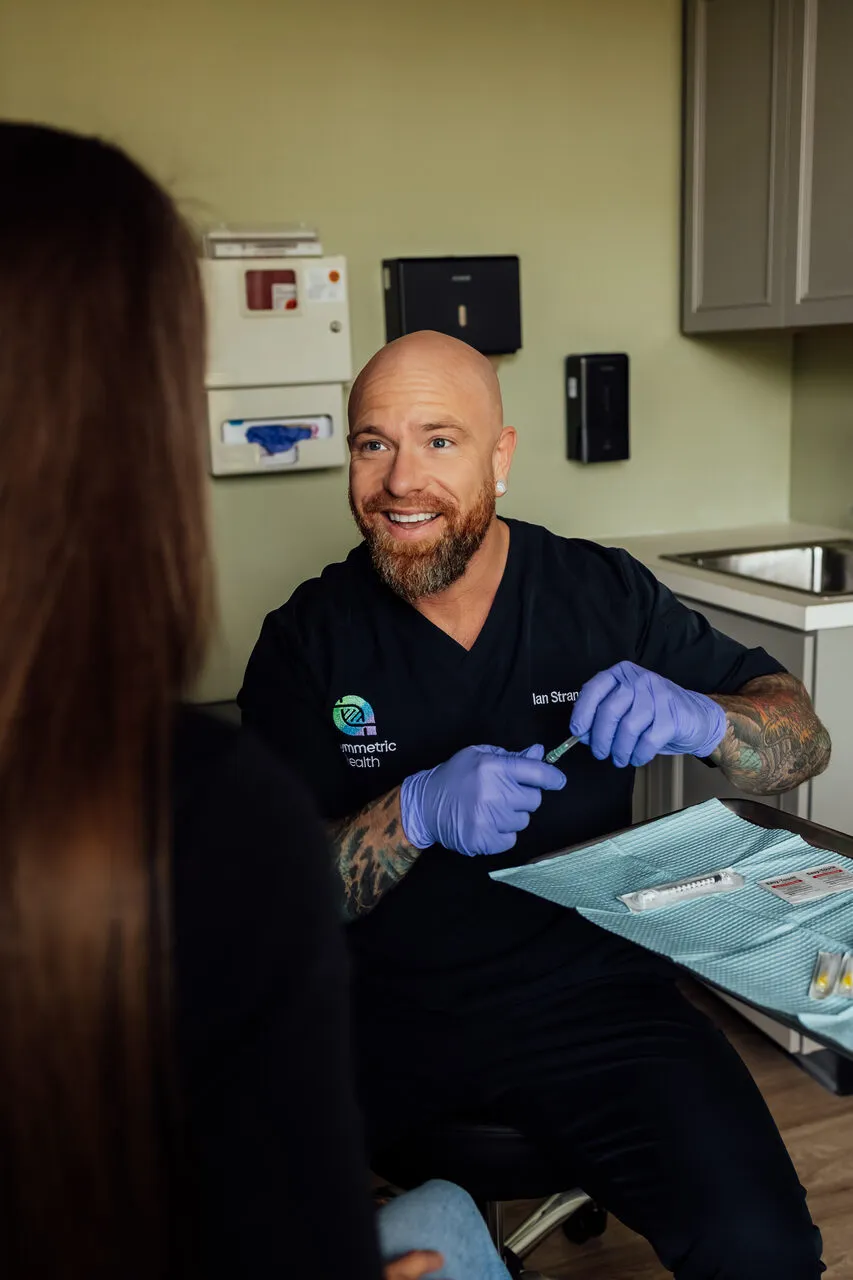 Dr. Ian Strand preparing a treatment with a patient at Asymmetric Health