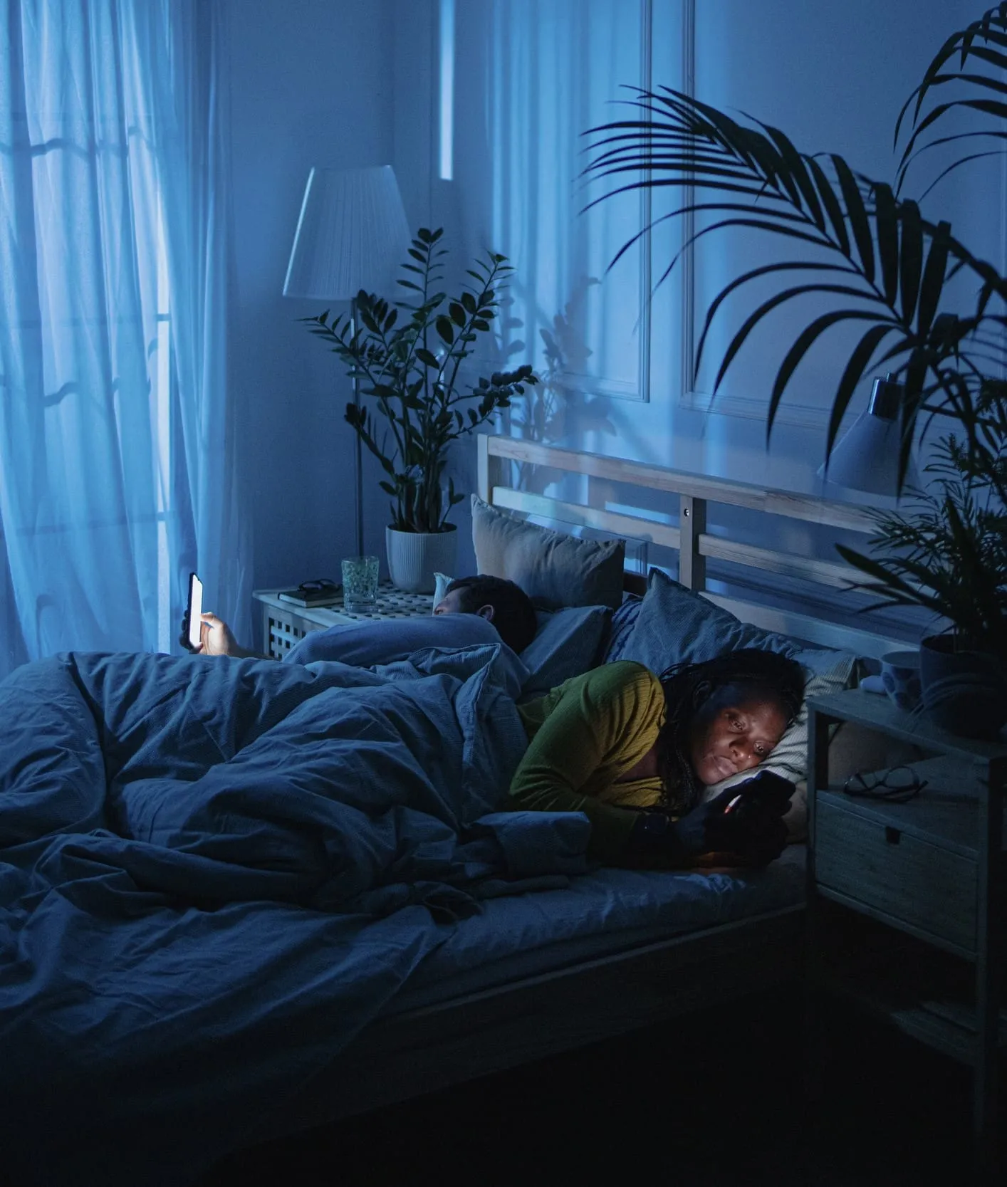 Phone screen glowing in bed illustrating poor sleep hygiene habits to avoid