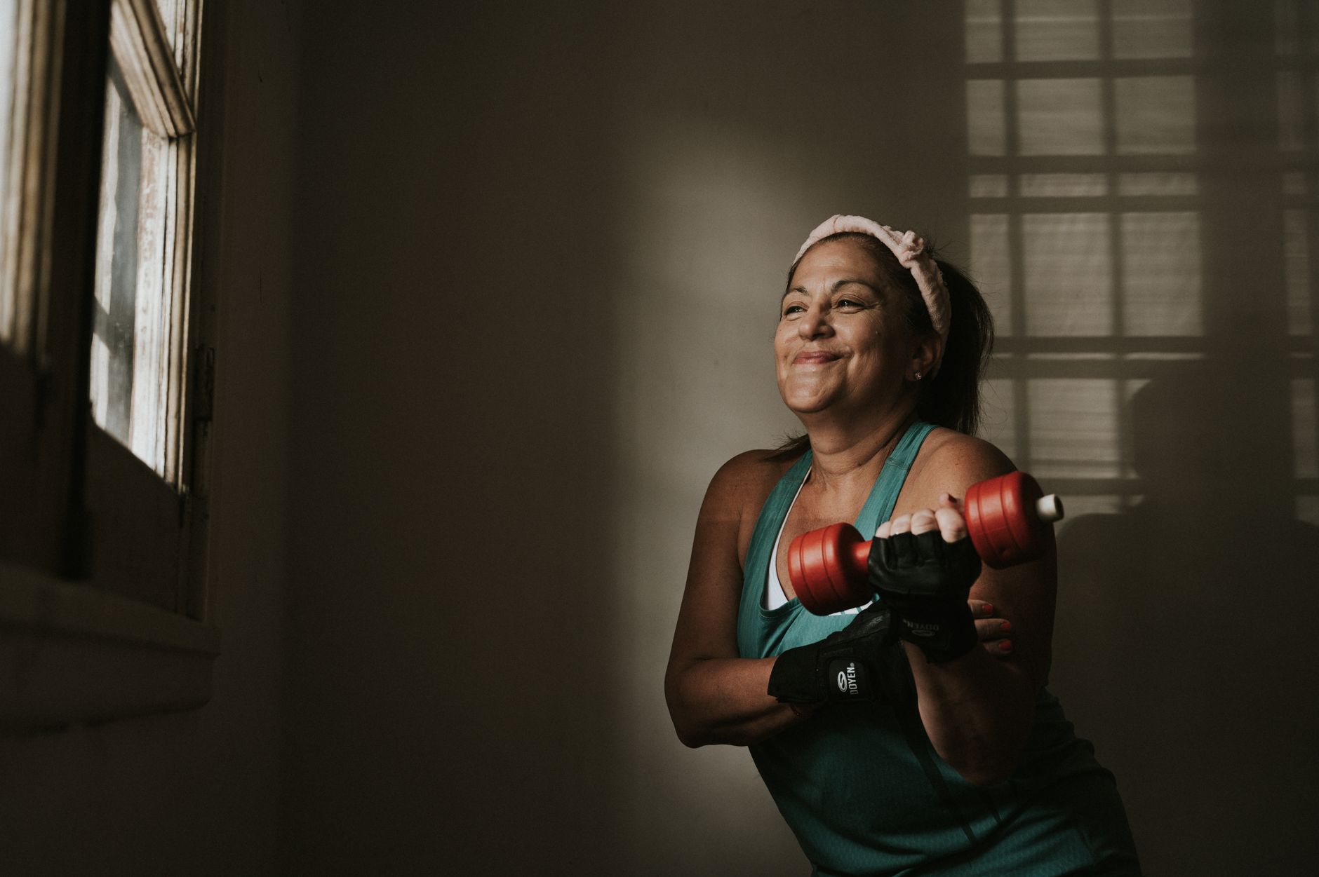 Middle-aged woman lifting dumbbells during an indoor strength training session, illustrating an article on body composition changes during menopause