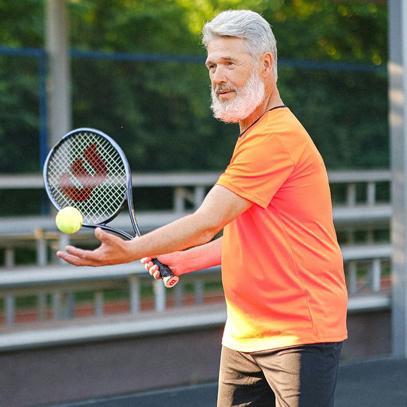 man-tennis Older man with beard and orange t-shirt playing tennis